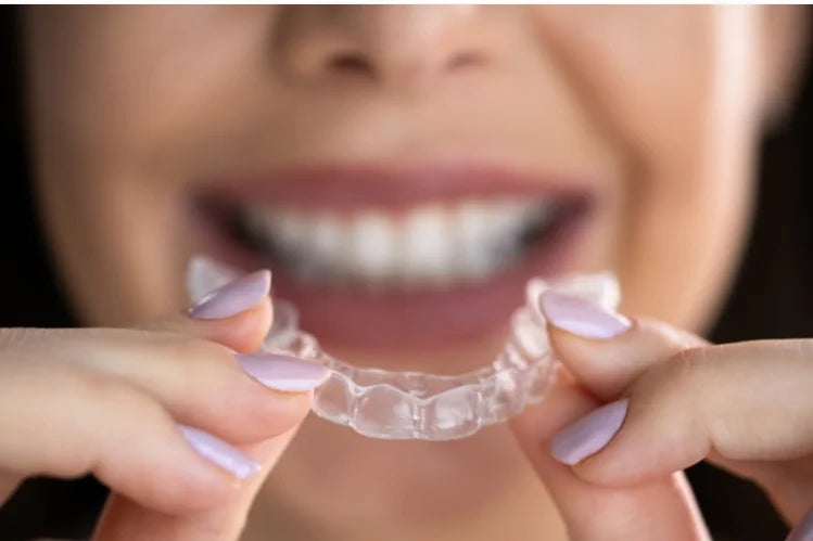 A woman applying nighttime clear aligners