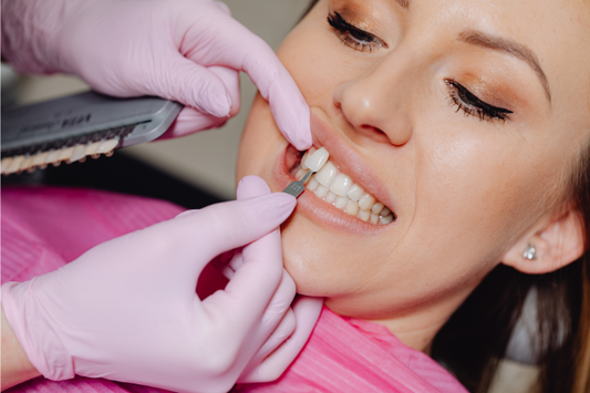 A dentist applying a veneer to a patient