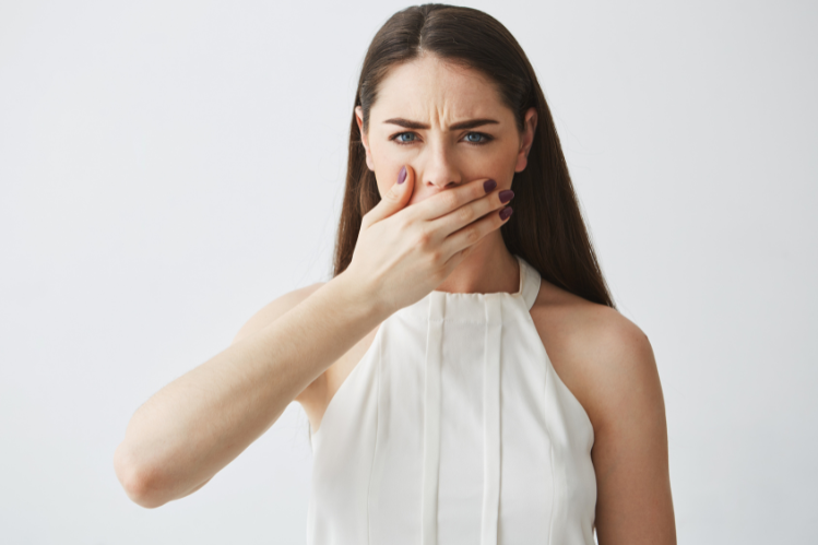 A woman covering her mouth in embarrassment