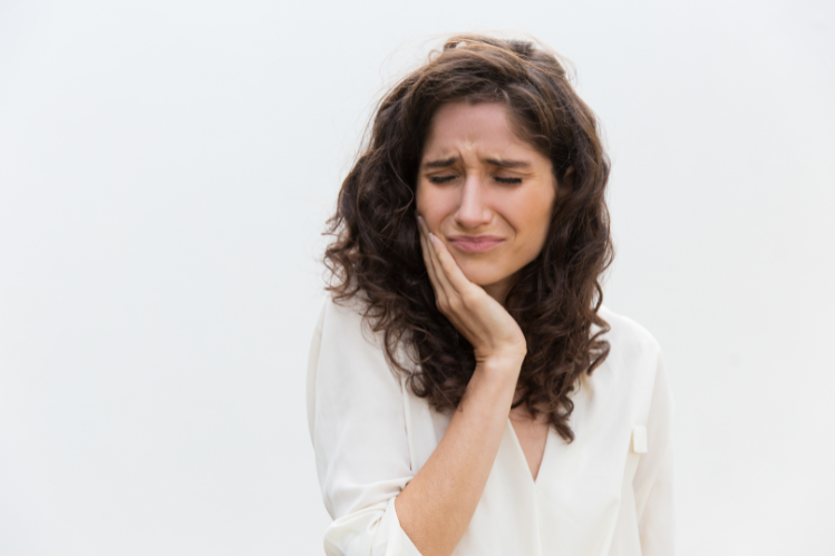 A woman holding her jaw because of a toothache