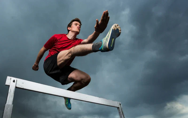 An athlete jumping over a hurdle