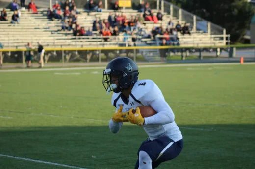 A football player wearing a sports mouth guard for protection on the field