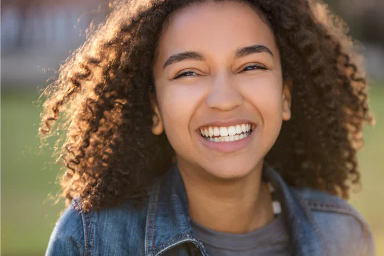 A teenage girl showing her perfectly aligned teeth 