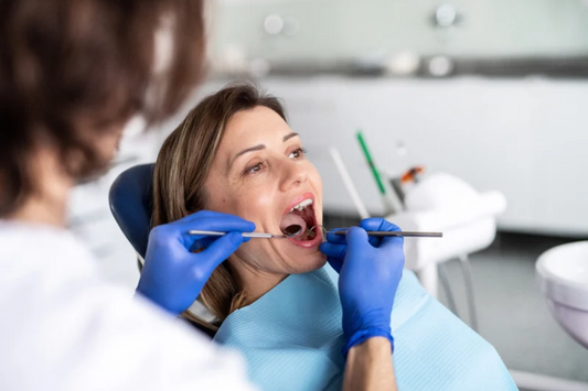 Dentist examining an adult woman's teeth during a checkup