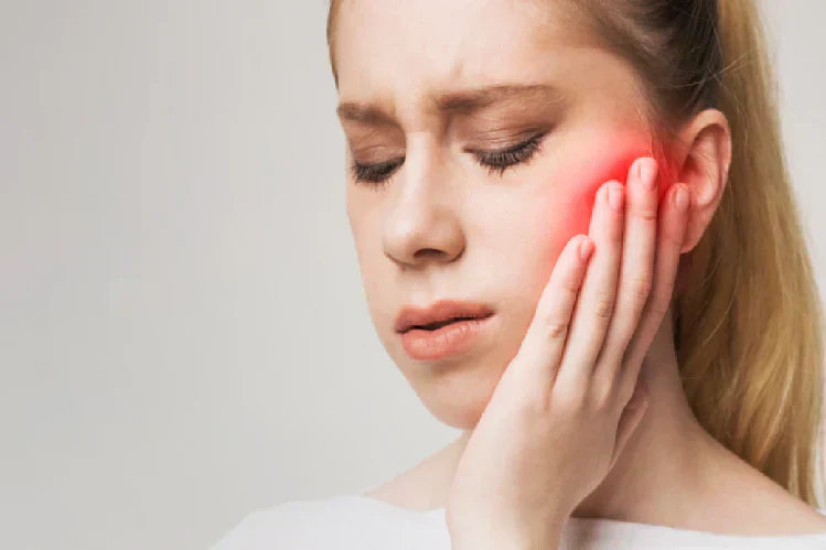 An image of a girl holding her jaw due to pain   