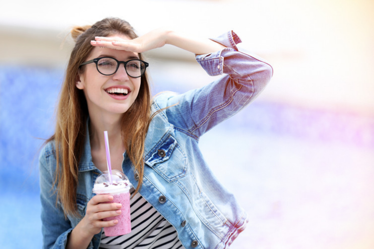A girl holding a glass of milkshake