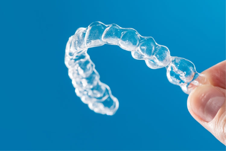 Close-up of a person holding a dental retainer