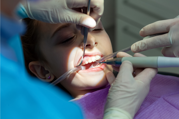 A girl getting her dental procedure done in a dentist’s office.