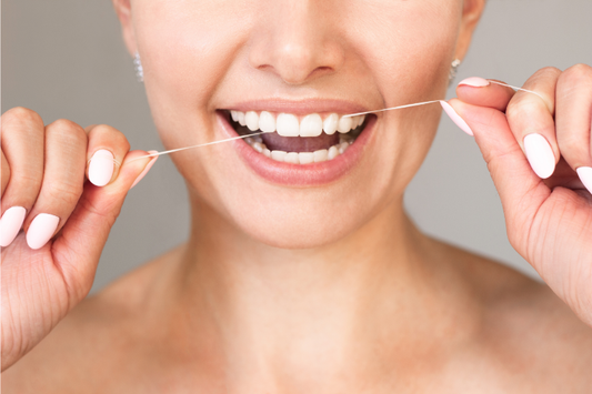 Smiling woman flossing between her front teeth