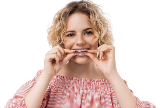 Smiling woman putting in a clear aligner