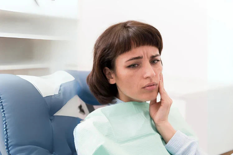 A woman with discomfort in her teeth
