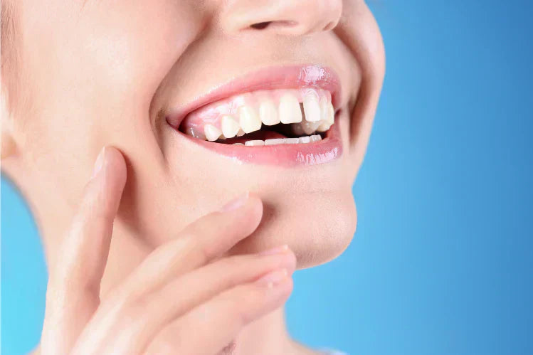 A woman smiling with a gap between her front teeth.