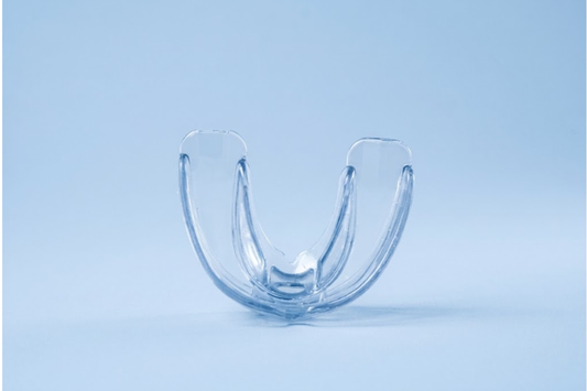 Clear boil and bite mouth guard on a light blue background