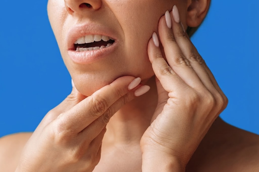 Woman pressing her jaw with both hands from jaw pain