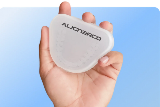 Hand holding an ALIGNERCO aligner case against a blue background