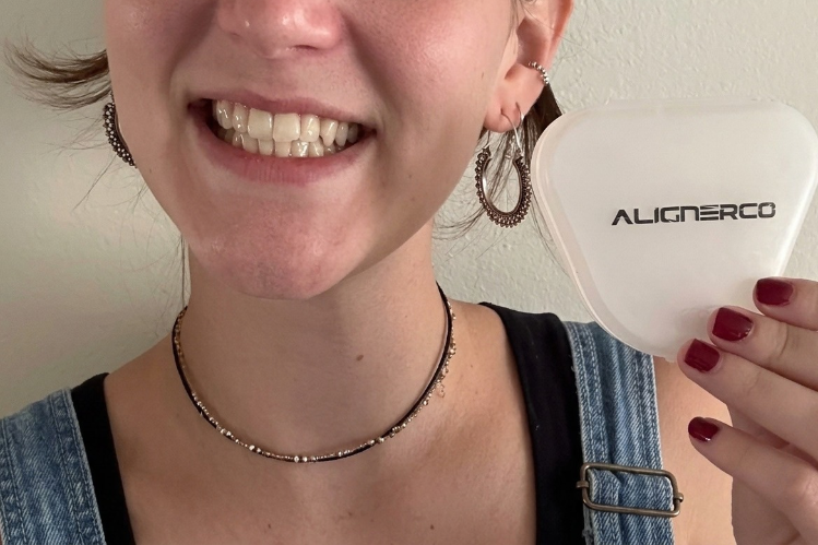 Smiling woman holding an ALIGNERCO aligner case
