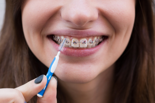 A girl flossing her teeth with braces