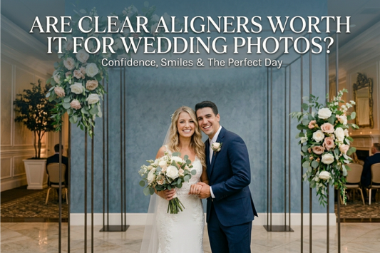 A smiling bride and groom stand before a bluish wall.