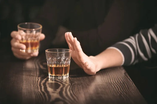 Someone refusing alcohol at a bar.
