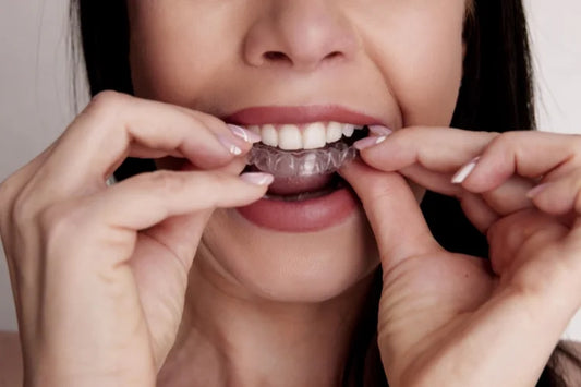 A woman putting on clear aligners 