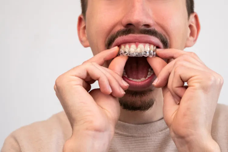  A close-up of a man applying a clear retainer.