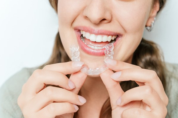 A closeup of a girl applying clear aligners.
