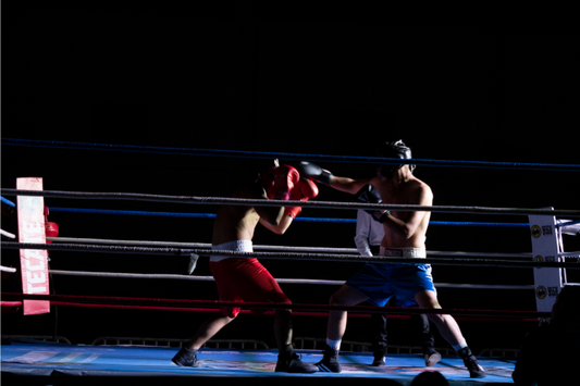 Two boxers sparring in a ring under dramatic lighting