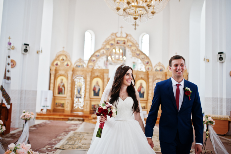A smiling couple entering the church hall for their wedding.  Caption: Couple Smiling Confidently Amplifies the Vibe