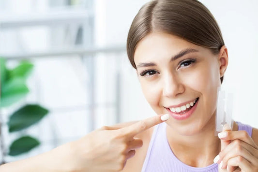 smiling woman holding a whitening shade strip